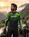Man in green and black 'Soul Fuel' motorcycle gear standing next to a motorcycle in a mountainous landscape.