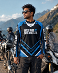 Man wearing a 'Wild and Two-Wheeled' motorcycle jersey with mountains in the background