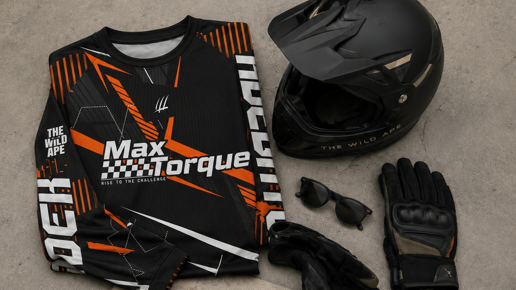 Motorcycle gear including a jersey, helmet, gloves, sunglasses, and keys on a concrete floor.