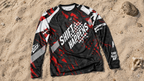 Black and red motocross jersey with text on a sandy background